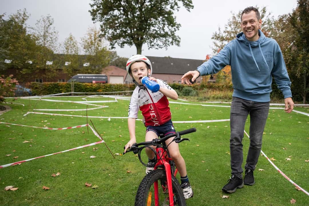 Wesley Kreder moedigt een jonge deelnemer op een mountainbike aan tijdens een oefenparcours